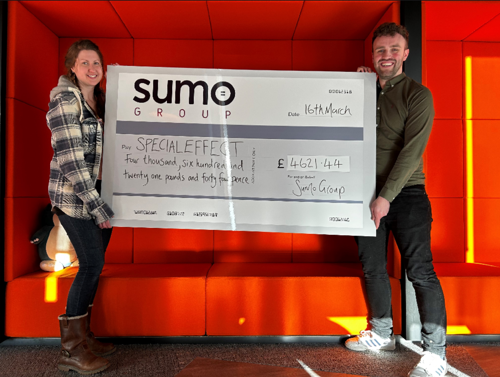 Sumo Group and SpecialEffect hold a giant cheque