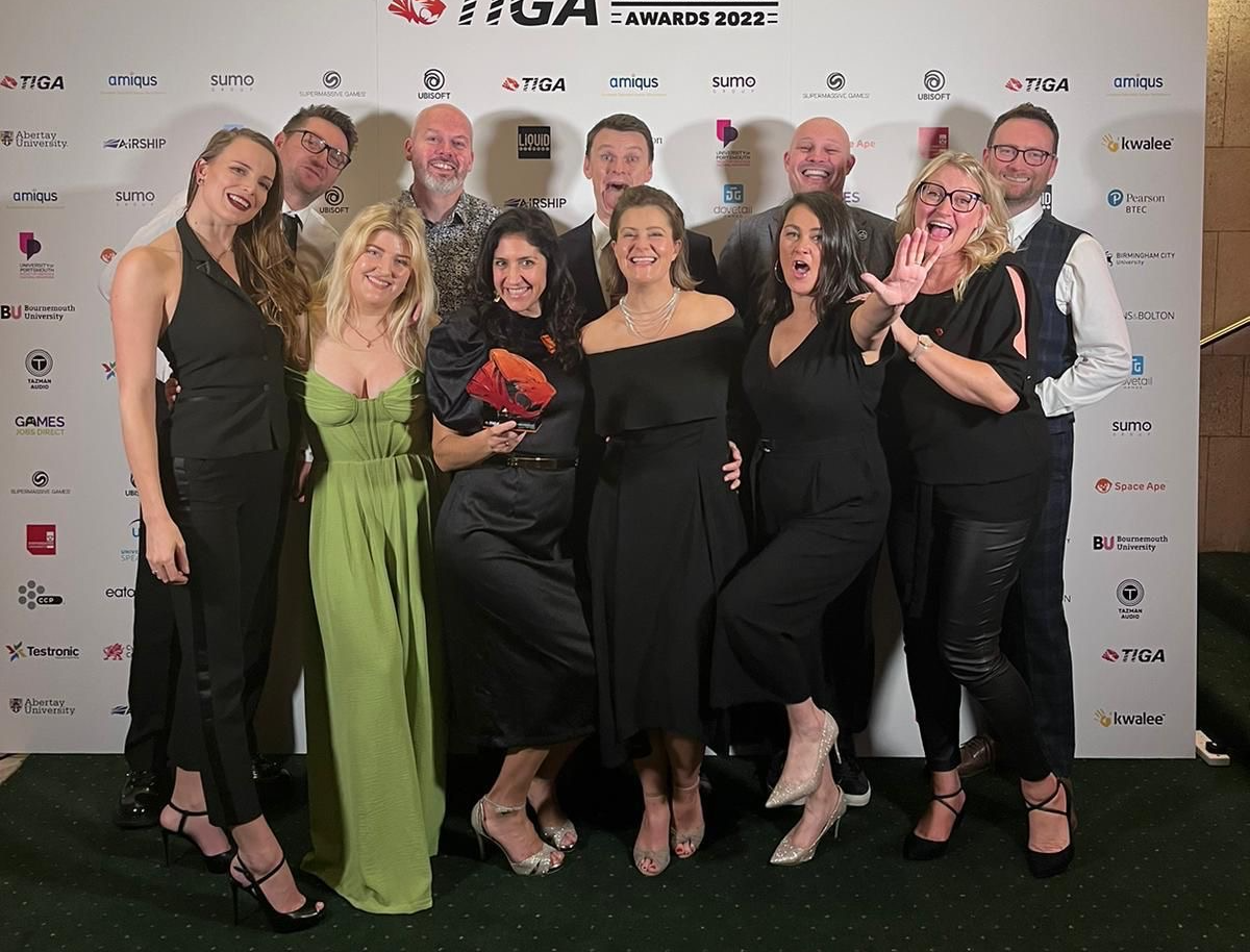 The Sumo Group team stand together smiling as they collect their TIGA Award.